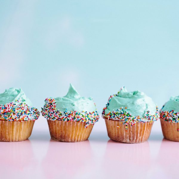 row of cupcakes with blue buttercream